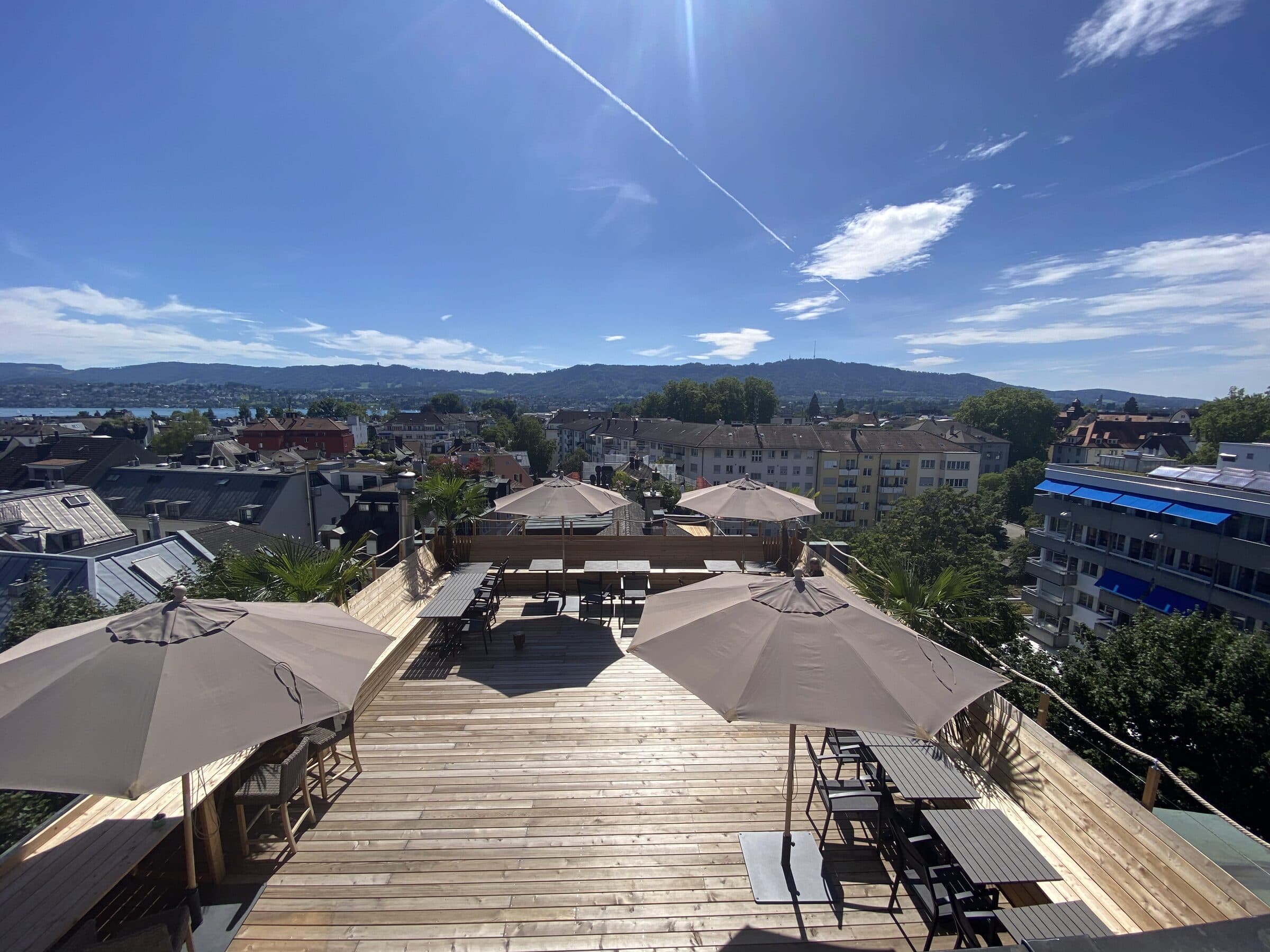 Rooftop terrace with parasols and a wide view over Zurich